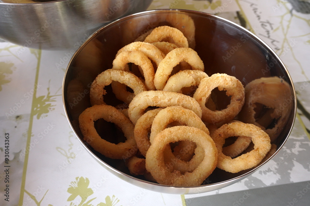 Calamari rings in deep frying in pan. Close up of frying onion rings in the fryer in hot oil. Calamari rings in deep frying in pan. Close up of frying onion rings in the fryer in hot oil.
