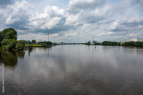 Hamburg, Germany, July 18, 2024 - Cityscape view over nature and industrial acitivity at the river Elbe photo