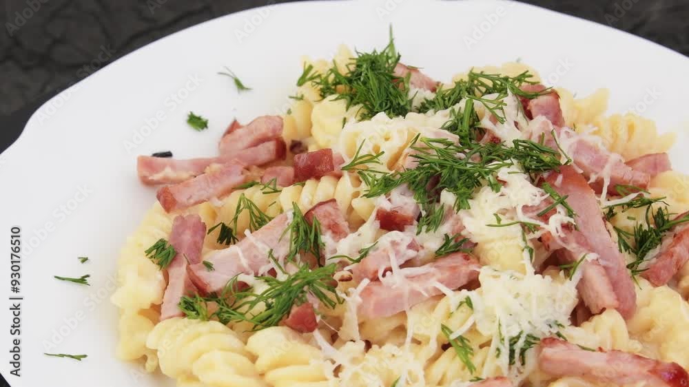 Pasta with beacon, cheese and dill on a white saucer. Rotation effect. Home cooking concept. Pasta with beacon, cheese and dill on a white saucer. Rotation effect. Home cooking concept.