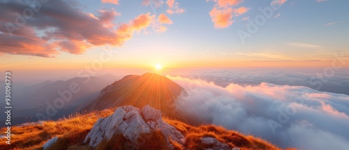  A sun-set crowns a mountain peak, clouds precede, a grassy expanse lies near