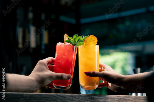 Close up of two people cheering cocktails in bar or disco club drinks and cocktails concept photo