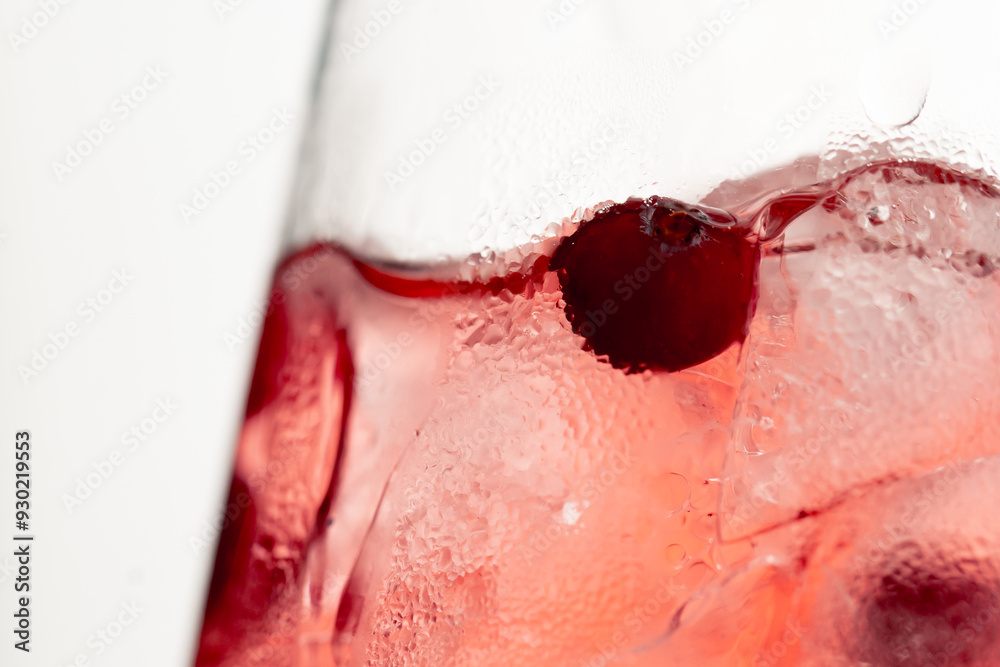 Fototapeta premium macro frame of glasses with cool red cocktail ice cubes condensation and drops on the glass fruity red balls
