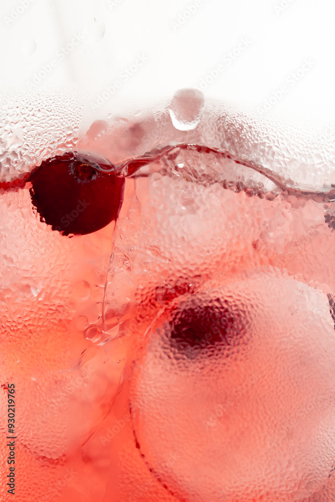 Fototapeta premium macro frame of glasses with cool red cocktail ice cubes condensation and drops on the glass fruity red balls