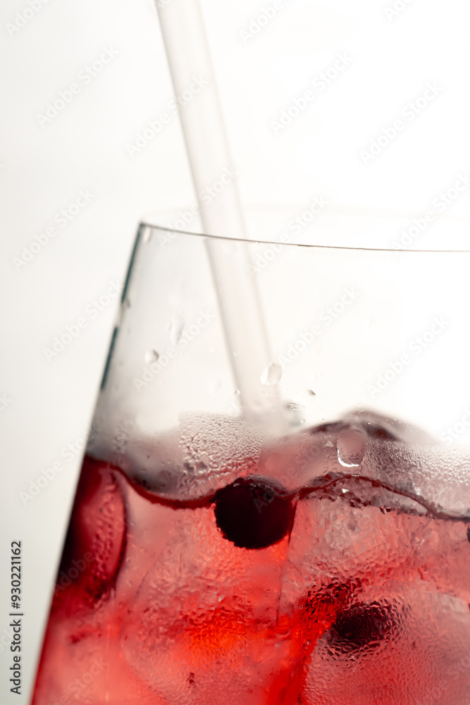 Fototapeta premium macro frame of glasses with cool red cocktail ice cubes condensation and drops on the glass fruity red balls