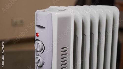 A housewife turns on an electric heater in cold weather.