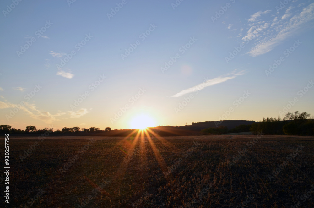Sunrise on sunset in summer, sun rays over horizon with beautiful sky and landscape background