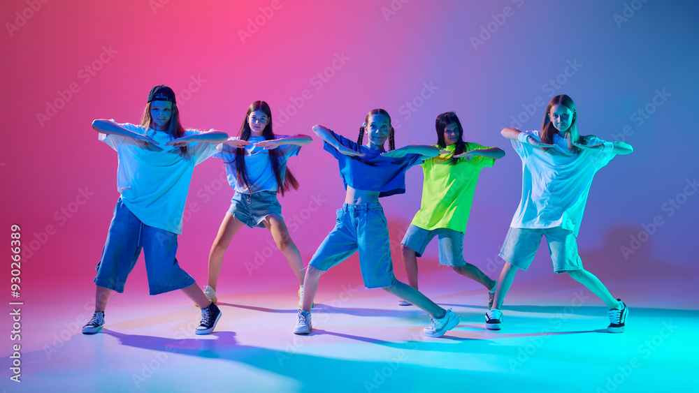 Young dancer, girls expressing themselves through powerful hip hop moves against gradient pink purple background in neon light. Concept of modern dance styles, youth culture, active lifestyle Young dancer, girls expressing themselves through powerful hip hop moves against gradient pink purple background in neon light. Concept of modern dance styles, youth culture, active lifestyle