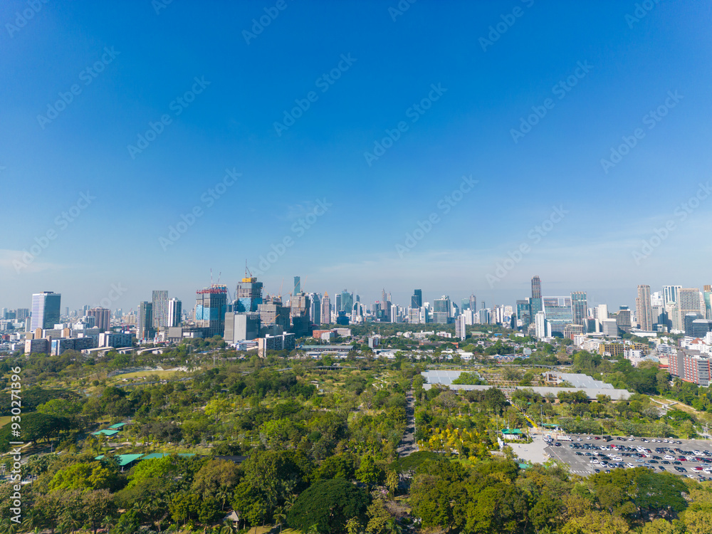 Naklejka premium Aerial view modern office building with tropical green tree park in Benchakitti public park downtown
