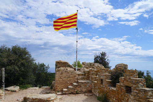 Photography catalonian flag is waving in the wind at the top of the  Castell de Begur, Giron