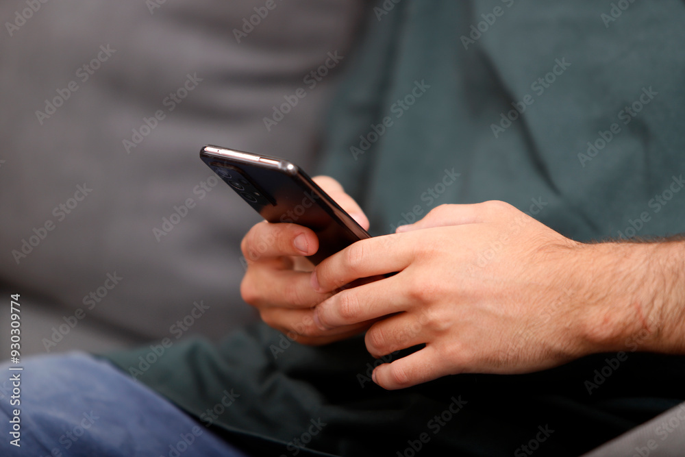 young man's hands holding a cell phone young man's hands holding a cell phone