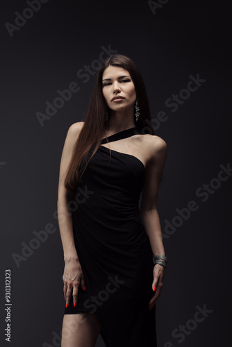 A stylish woman in a sophisticated black dress and chic accessories strikes a confident pose. Embodies class, elegance, and fashion.