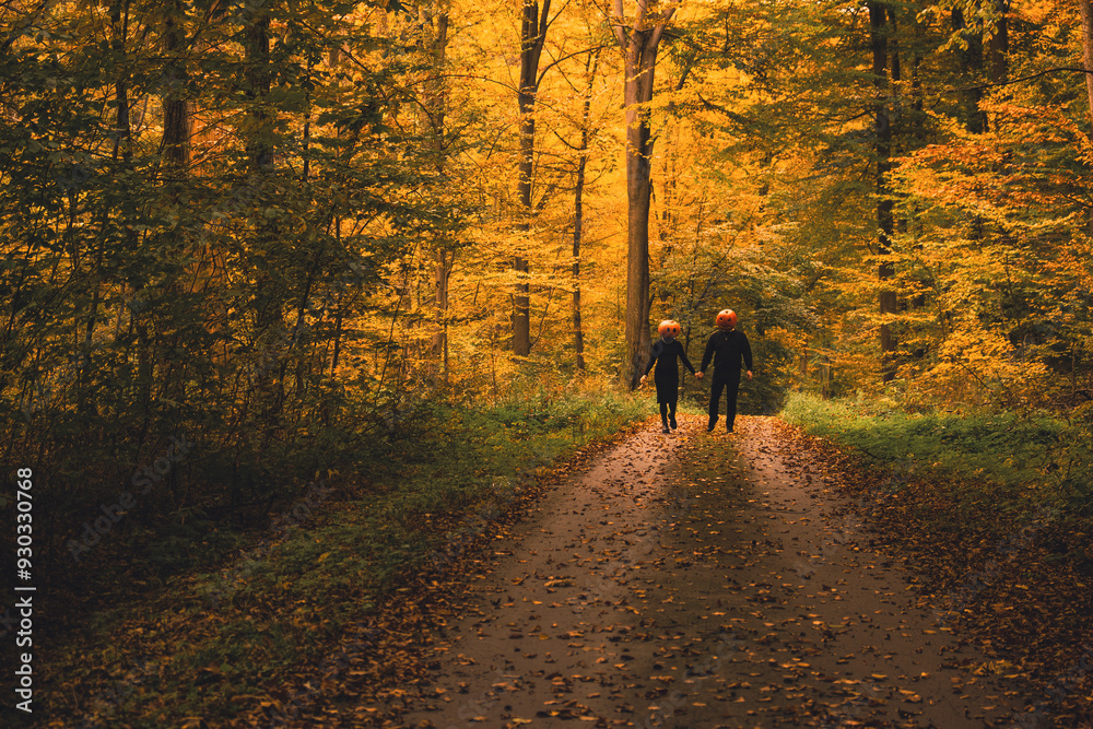 couple with pumpkin head in fall forest