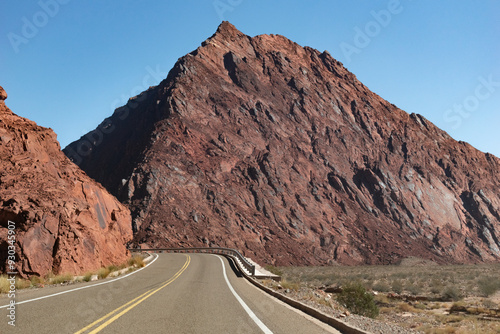 Ruta al lado de montañas rojizas.