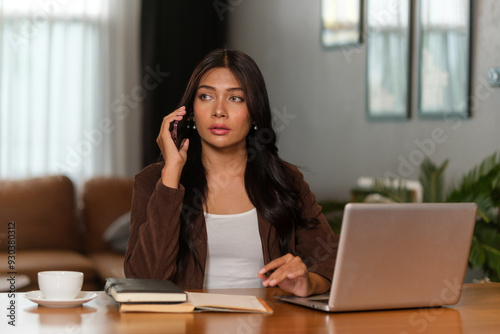 Wallpaper Mural Businesswoman sitting at a desk, looking serious and attentive as she listens to a phone conversation. Torontodigital.ca
