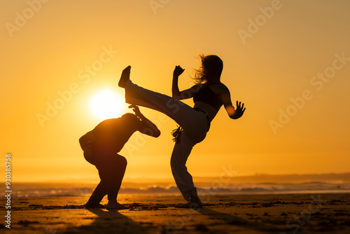 Couple practicing capoeira martial art at sunset on the beach photo