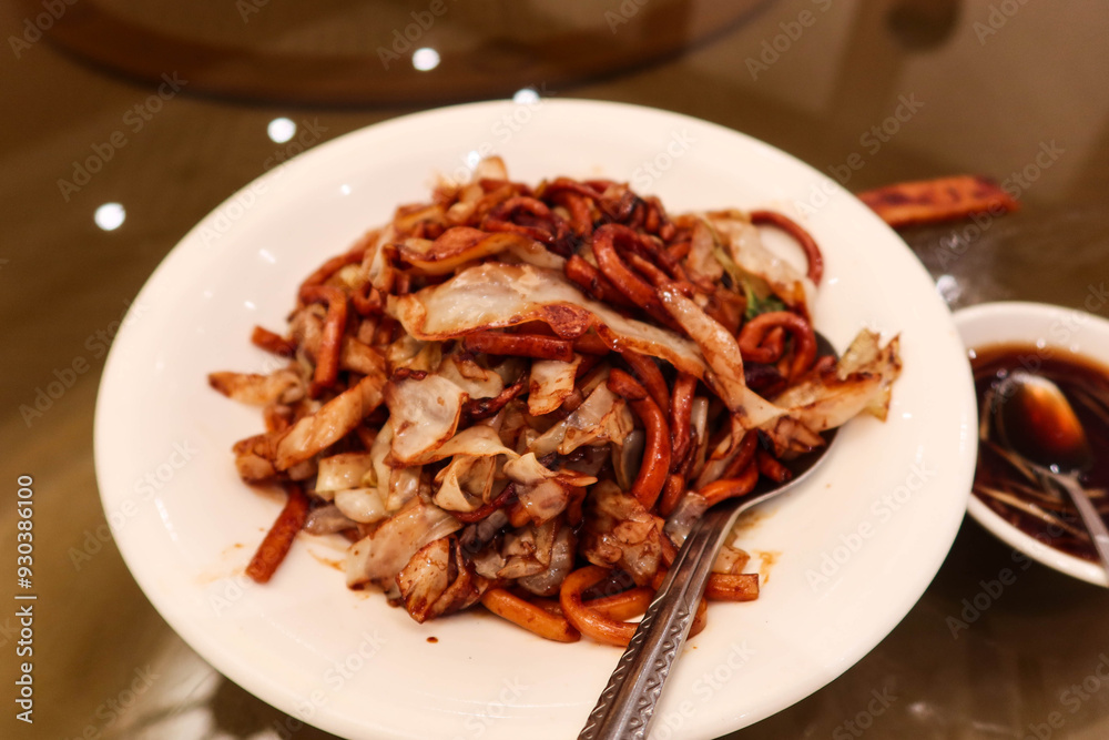 close up of Chinese Shanghai style stir fried pork beef vegetables noodles with soy sauce on a white plate close up of Chinese Shanghai style stir fried pork beef vegetables noodles with soy sauce on a white plate