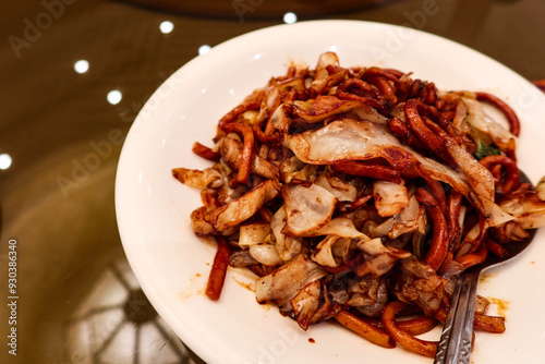 close up of Chinese Shanghai style stir fried pork beef vegetables noodles with soy sauce on a white plate