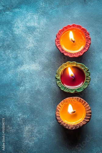 Clay Diya lamps lit on blue background