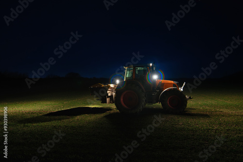  Agricultural tractor with headlights at night photo