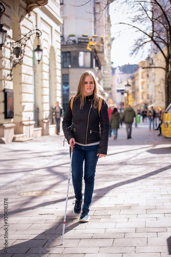 Full length of a visually impaired woman using her cane to walking down the street