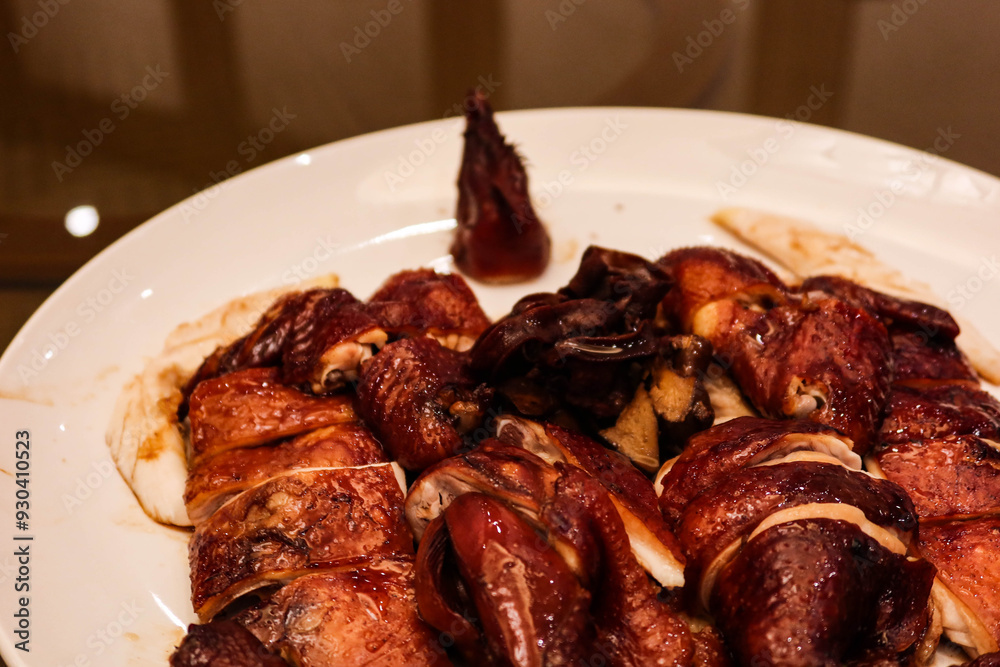 close up of grilled soy sauce chicken on a white plate with crispy skin close up of grilled soy sauce chicken on a white plate with crispy skin
