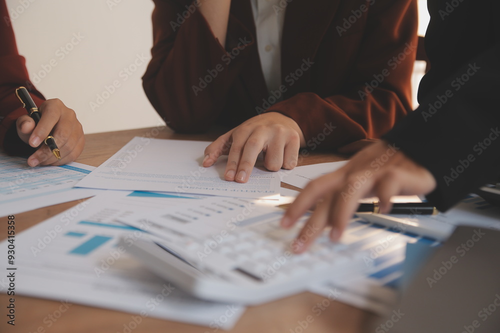 Group of confident business people point to graphs and charts to analyze market data, balance sheet, account, net profit to plan new sales strategies to increase production capacity. Group of confident business people point to graphs and charts to analyze market data, balance sheet, account, net profit to plan new sales strategies to increase production capacity.