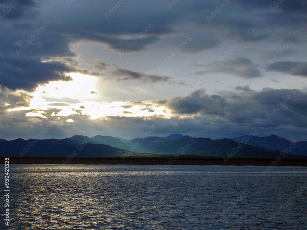 Dramatic cloudy sky over sea, Kamchatka Peninsula, Russia. Mountains on Northern Dramatic cloudy sky over sea, Kamchatka Peninsula, Russia. Mountains on Northern