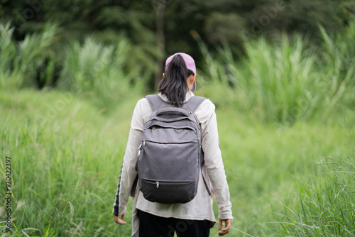 Mujer joven caminando de espaldas al aire libre en medio del césped photo