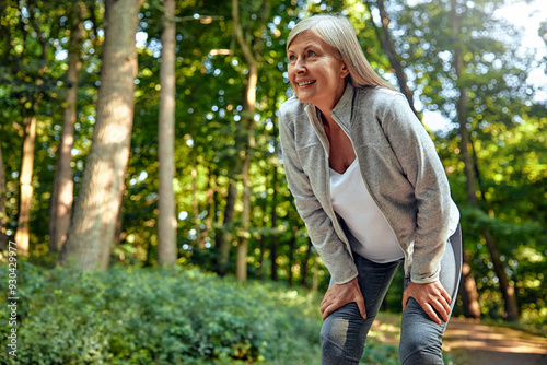 An Exhausted Woman Taking a Welldeserved Break in the Beautiful Nature During Outdoor Exercise photo