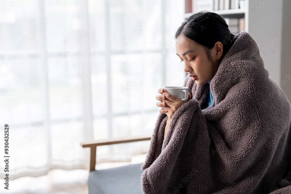 A woman is sitting in a chair with a blanket wrapped around her A woman is sitting in a chair with a blanket wrapped around her