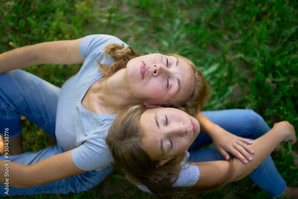 mother and teenage girls with long blond hair spend time together in the sunlit park mother and teenage girls with long blond hair spend time together in the sunlit park