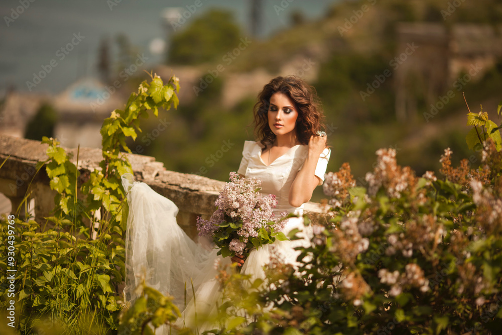 Portrait of beauty bride in white dress. The bride is holding a wedding bouquet of lilacs. Portrait of beauty bride in white dress. The bride is holding a wedding bouquet of lilacs.
