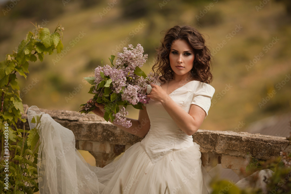 Portrait of beauty bride in white dress. The bride is holding a wedding bouquet of lilacs. Portrait of beauty bride in white dress. The bride is holding a wedding bouquet of lilacs.