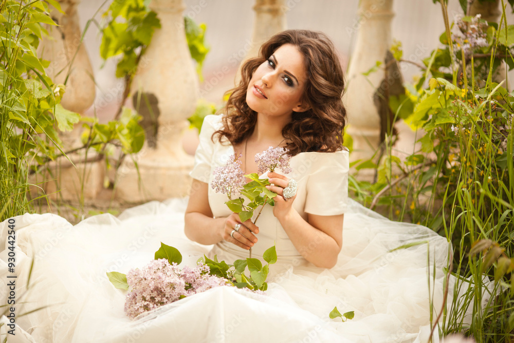 THE EUROPEAN BEAUTIFUL BRIDE WITH THE BEAUTIFUL DARK HAIR WITH THE BOUQUET ON THE BACKGROUND OF THE GREAT BRUSH OF LILAC THE EUROPEAN BEAUTIFUL BRIDE WITH THE BEAUTIFUL DARK HAIR WITH THE BOUQUET ON THE BACKGROUND OF THE GREAT BRUSH OF LILAC