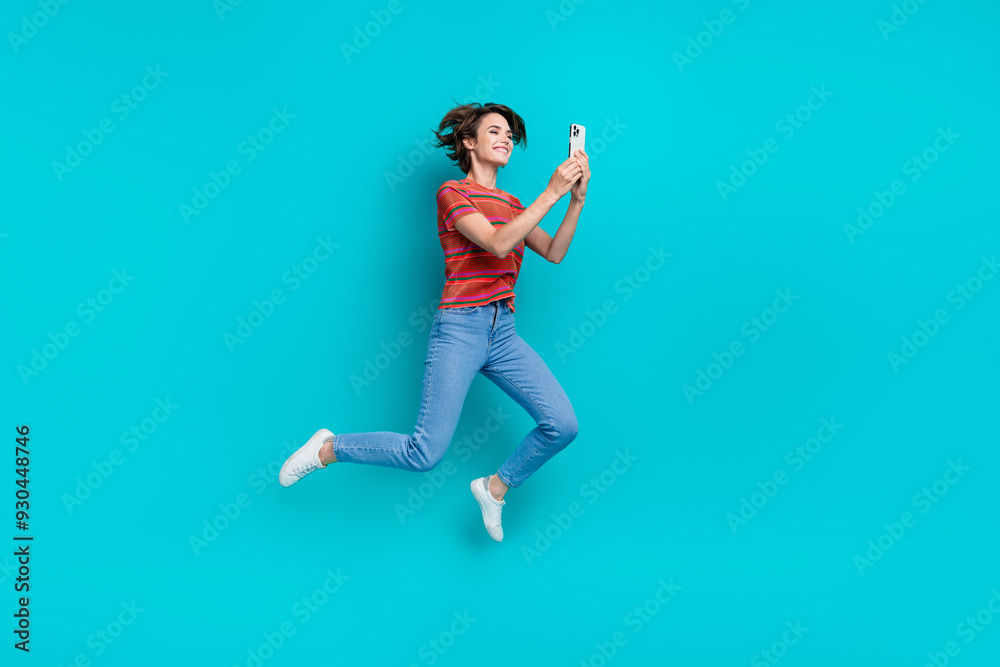 Full length photo of cheerful positive girl addicted user wear trendy clothes read comment post isolated on cyan color background Full length photo of cheerful positive girl addicted user wear trendy clothes read comment post isolated on cyan color background