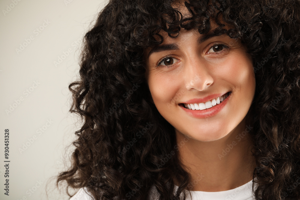 Happy young woman on light grey background, closeup. Dental veneers Happy young woman on light grey background, closeup. Dental veneers