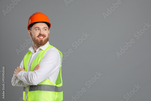 Engineer in hard hat on grey background, space for text