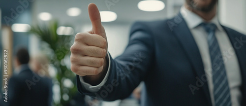 A businessman giving a thumbs-up gesture in a corporate meeting. businessman thumbs-up photo