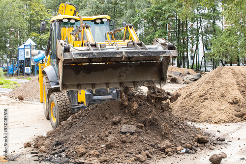 Фотография A bulldozer is actively loading soil into a sizable pile on a construction site