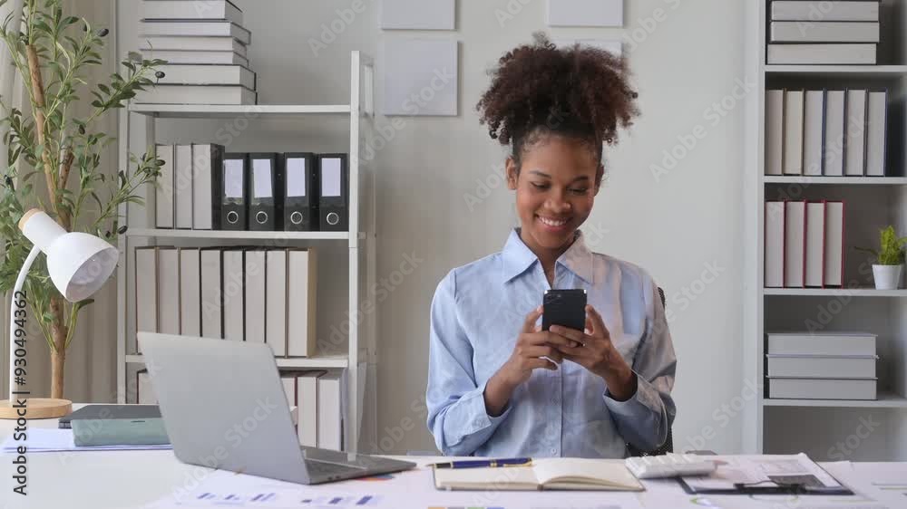 Businesswoman using smartphone at office desk