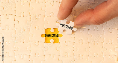 Overcoming perfectionism symbol. Concept words Overcoming perfectionism on beautiful white puzzles. Beautiful yellow background. Businessman hand. Business Overcoming perfectionism concept. Copy space photo