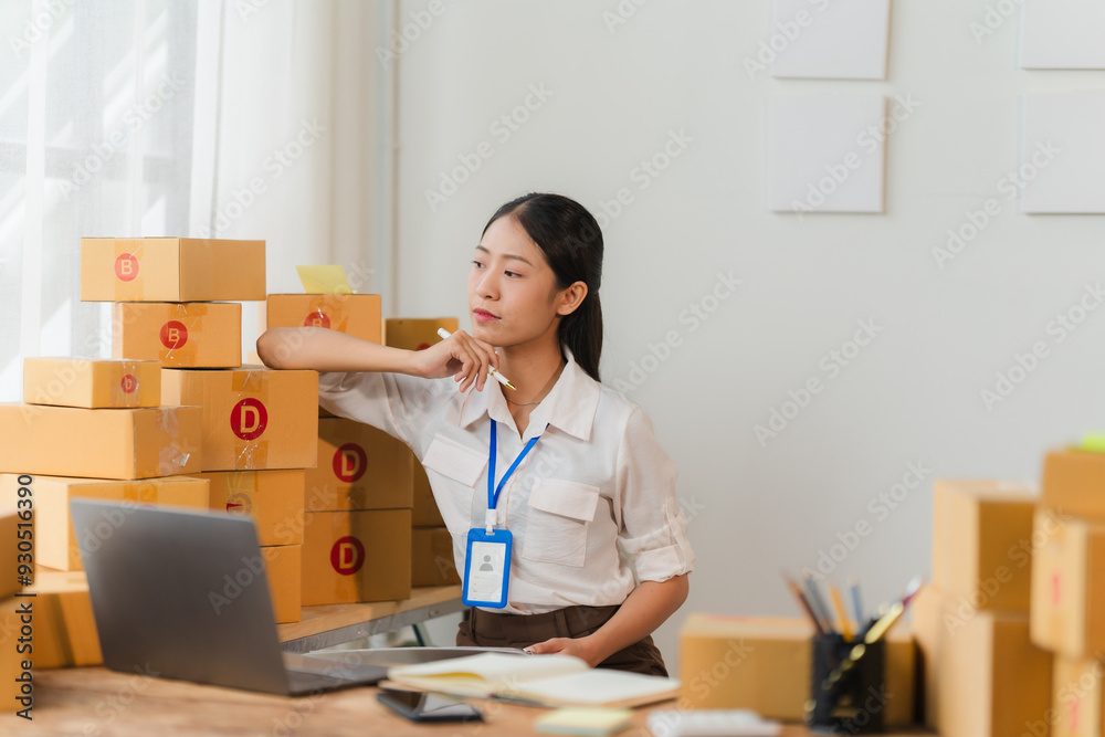 Entrepreneurial Dreams: A young entrepreneur contemplates her future, surrounded by stacks of cardboard boxes and a laptop, reflecting the dedication and aspirations of online business owners. Entrepreneurial Dreams: A young entrepreneur contemplates her future, surrounded by stacks of cardboard boxes and a laptop, reflecting the dedication and aspirations of online business owners.