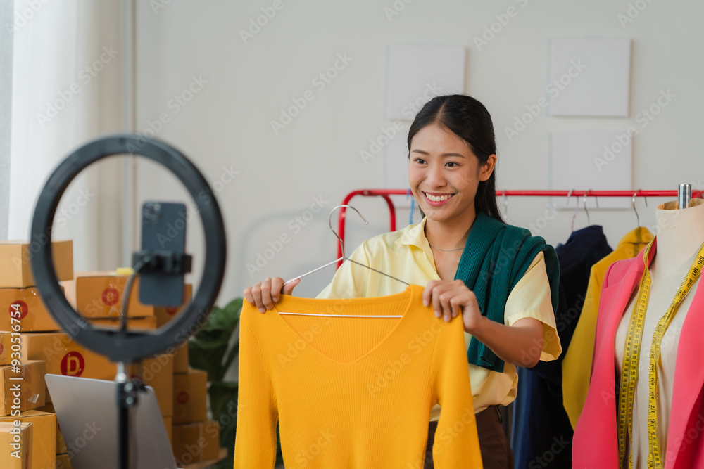 Smiling Influencer: A young woman, radiating confidence, holds up a yellow sweater in front of a ring light, showcasing her product to an online audience. Her vibrant energy and genuine smile draw vie Smiling Influencer: A young woman, radiating confidence, holds up a yellow sweater in front of a ring light, showcasing her product to an online audience. Her vibrant energy and genuine smile draw vie