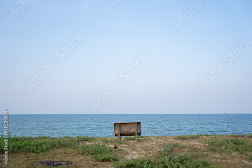 Public chair on the beach overlooking endless sea view.