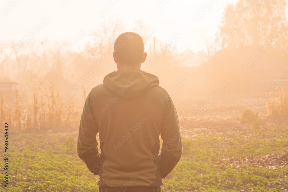 Back portrait of a man enjoying a beautiful autumn foggy in the countryside Back portrait of a man enjoying a beautiful autumn foggy in the countryside
