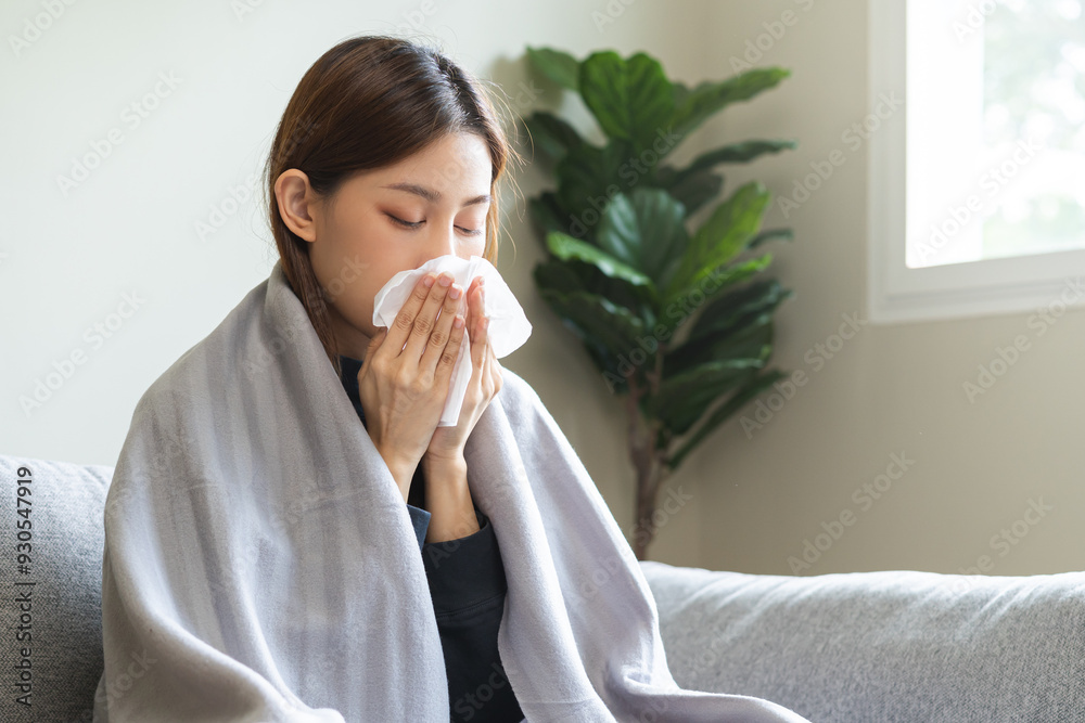 Sick, coronavirus or covid-19, attractive asian young woman, girl have a fever, flu and hand in use tissues paper sneezing nose, runny while sitting on sofa, couch at home. Health care on virus person Sick, coronavirus or covid-19, attractive asian young woman, girl have a fever, flu and hand in use tissues paper sneezing nose, runny while sitting on sofa, couch at home. Health care on virus person