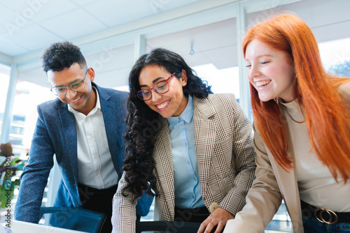 Close up of young smiling latin businesspeople team collaborating and doing business working in a meeting room office 