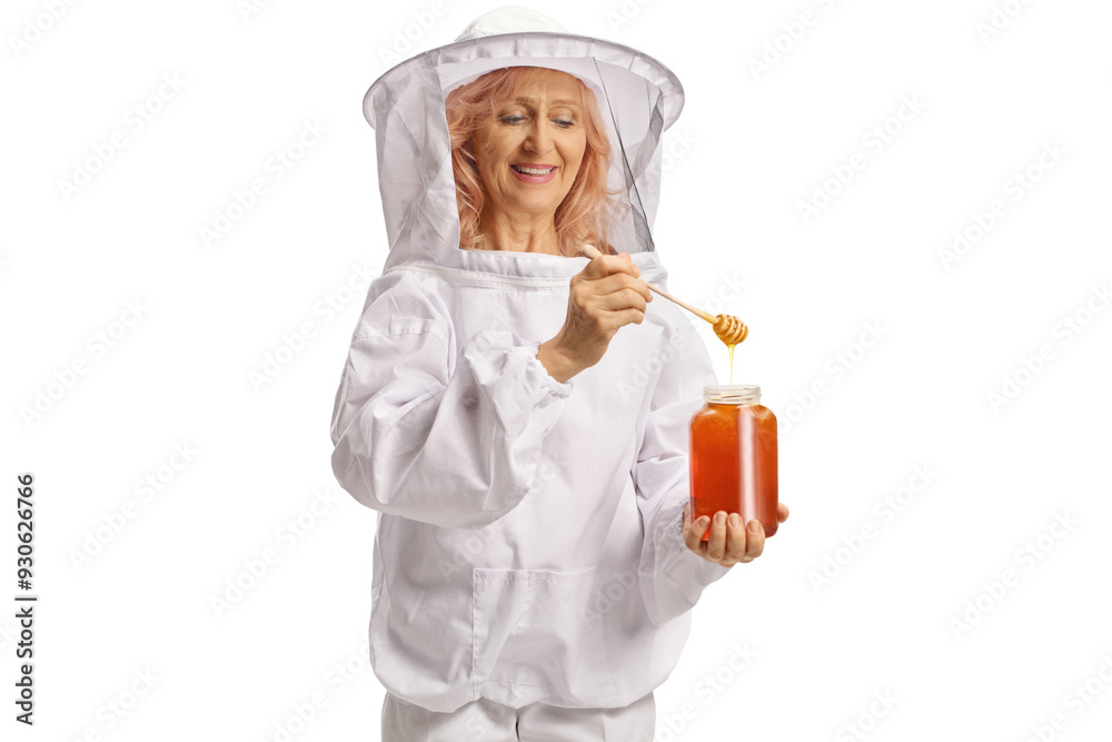Apiarist in a uniform trying honey from a jar of honey and smiling Apiarist in a uniform trying honey from a jar of honey and smiling