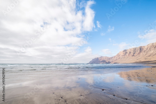 Wallpaper Mural Famara beach with the cliffs in the background reflected in the water of the shore, in the north of Lanzarote Island, Canary Islands, Spain Torontodigital.ca