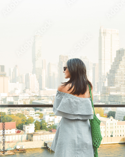 Bangkok, Thailand - 11th february, 2024:caucasian woman tourist enjoy shopping mall look out famous viewpoint over river in sunny hot day in southeast asia popular destination Bangkok city in Thailand photo